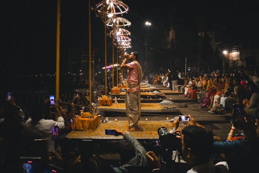 Night view of the traditional Ganga Aarti ceremony in Varanasi, with priests performing religious rituals along the riverbanks.
